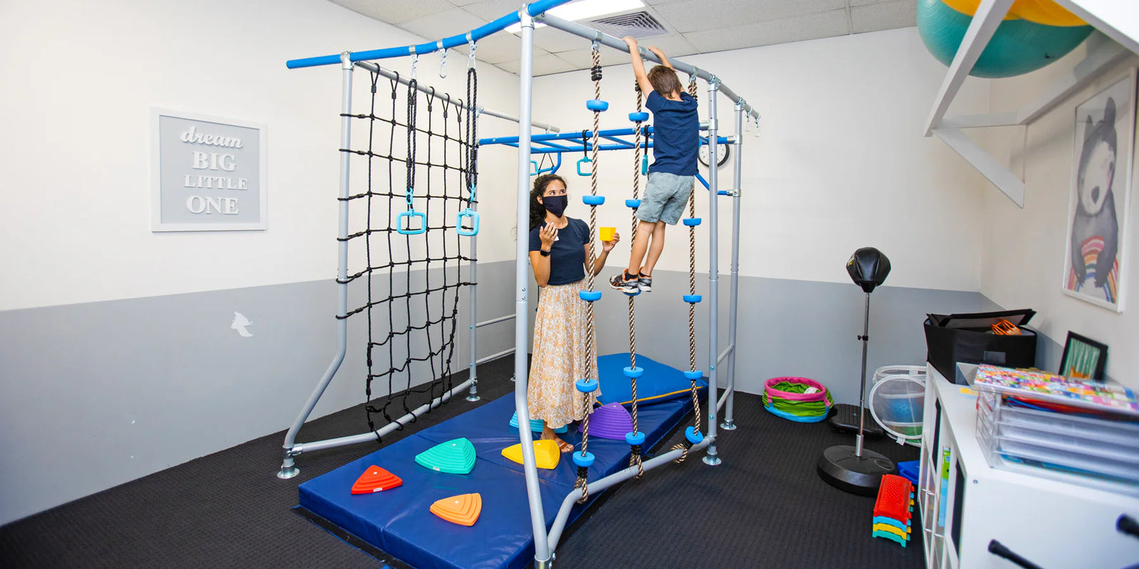 Children playing on a playground structure in an indoor playroom.